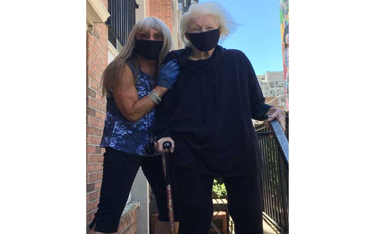 Masked Vintage Fitness Trainer Dee and client working on stairs