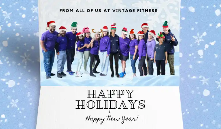 Vintage Fitness team wearing festive holiday hats and purple shirts wishing seniors happy holidays and a healthy new year