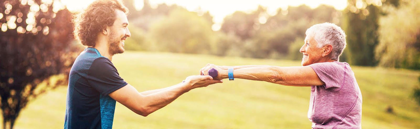 Senior working out with help of personal trainer